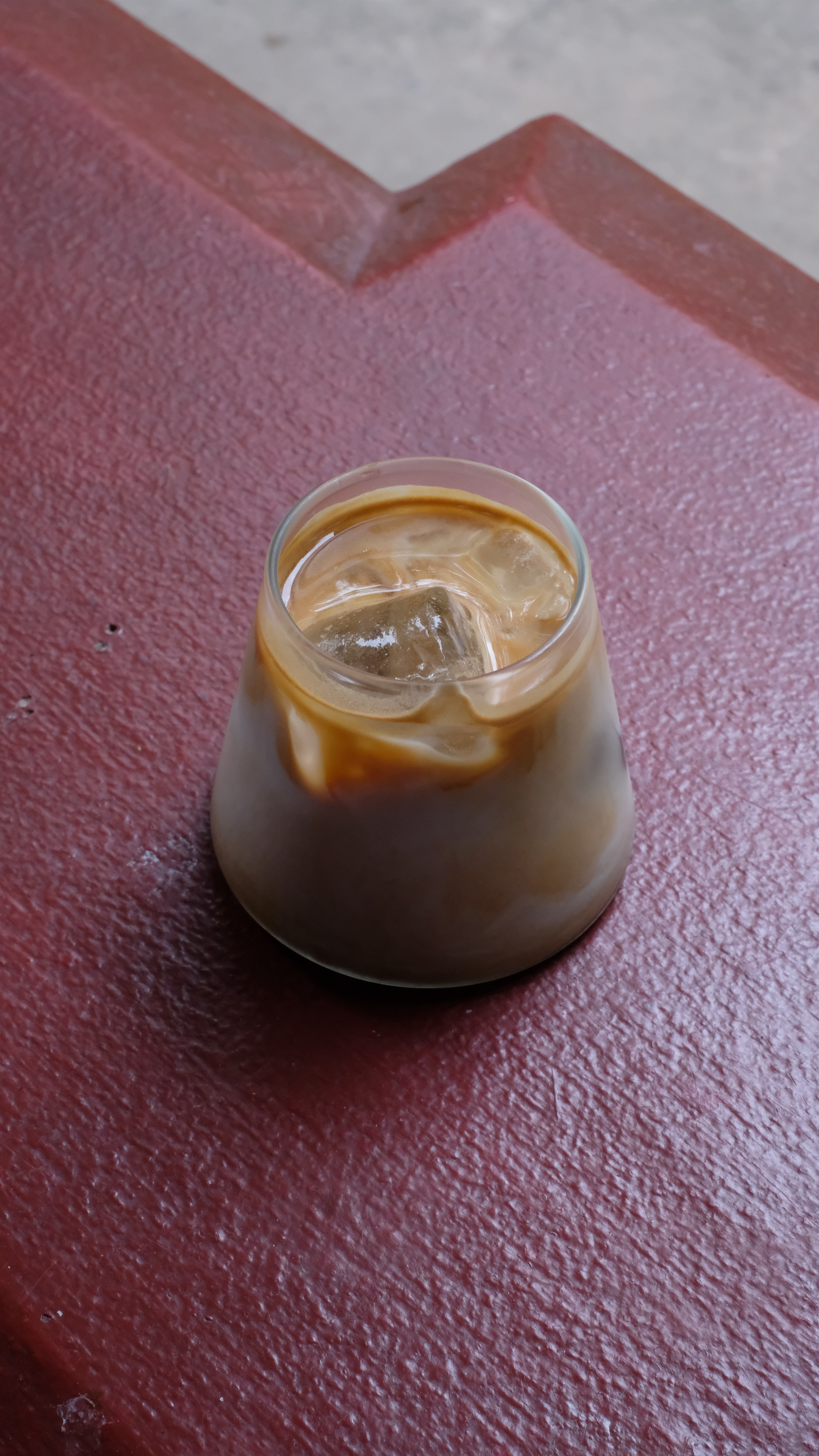 An iced coffee on a red countertop